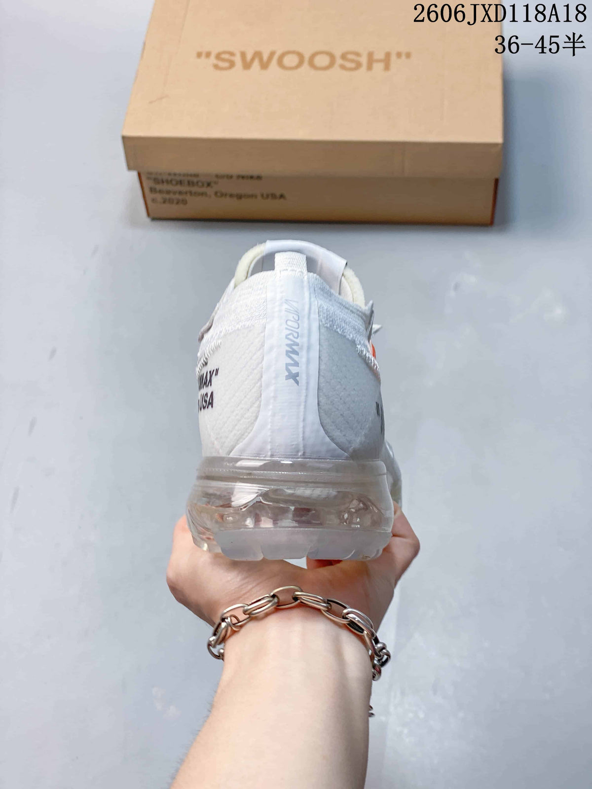 Rear view of a white sneaker showing the heel and clear sole