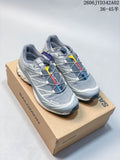 Pair of grey Salomon trail-style shoes with cord lacing and lugged soles on a box