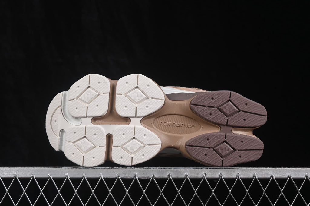 Bottom view of the New Balance sneakers showing the segmented cream, brown, and white outsole.