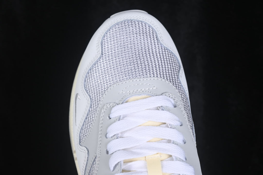 Top-down close-up of the grey mesh toe box, white laces, and layered toe overlays.