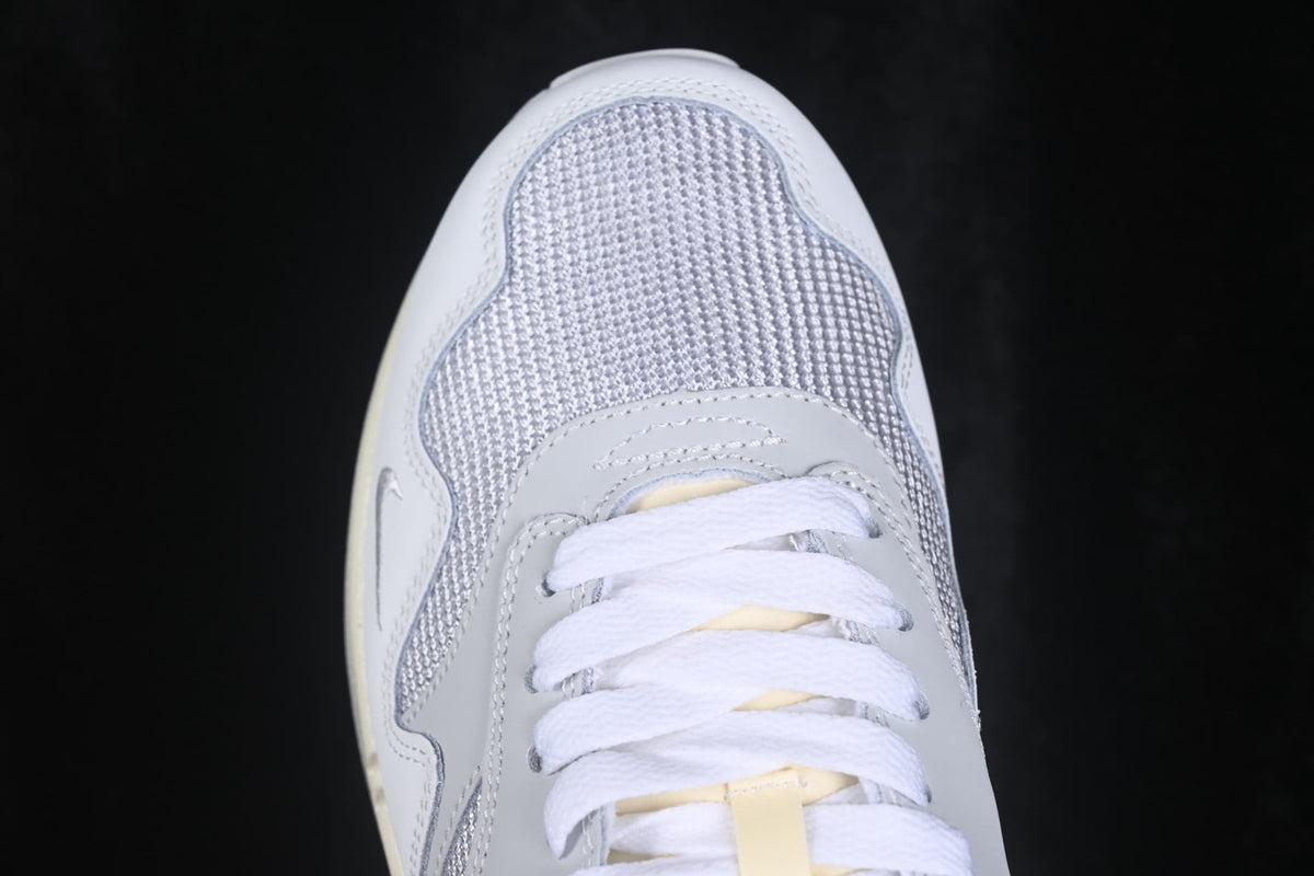 Top-down close-up of the grey mesh toe box, white laces, and layered toe overlays.