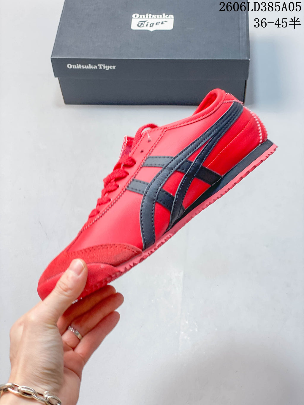 Side profile of the red low-top sneaker with dark stripes