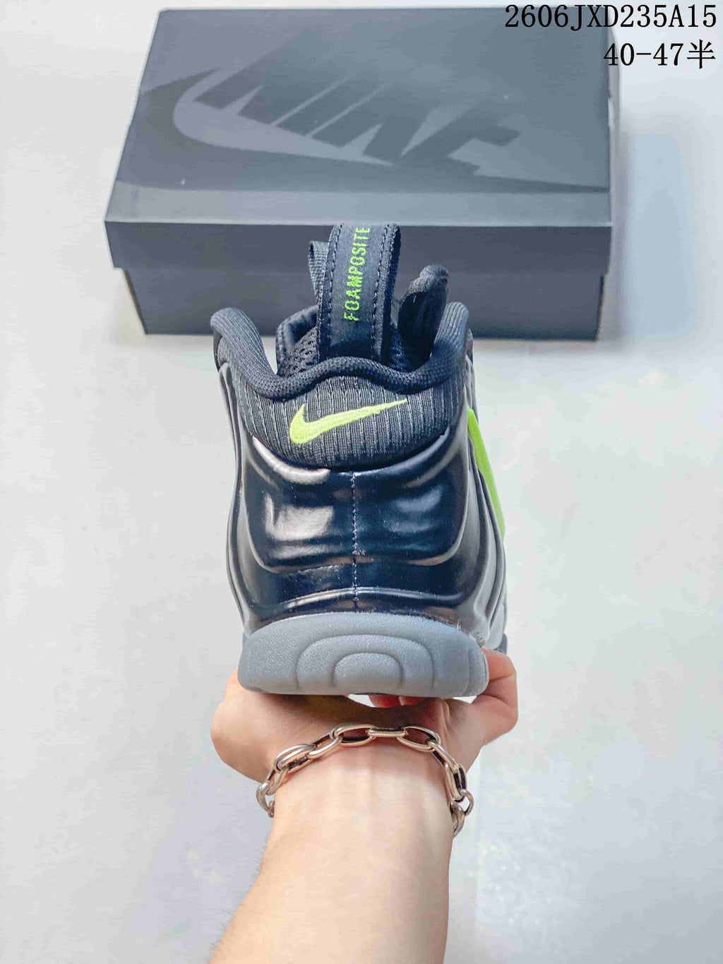 Rear view showing the heel, pull tab, and gray outsole of a dark Nike Foamposite One shoe.
