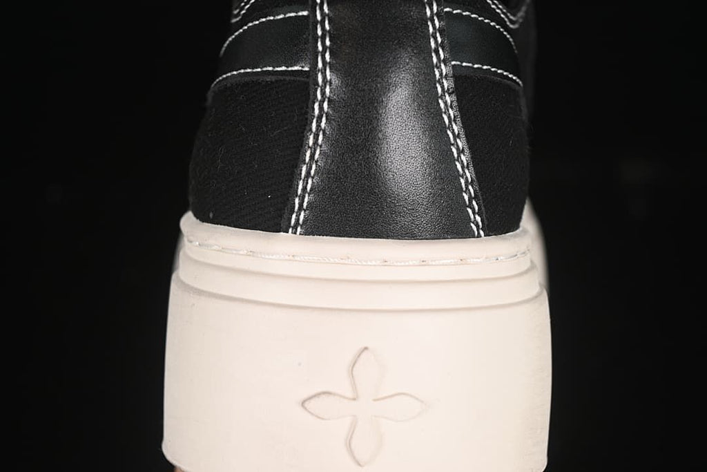 Rear view of the sneaker showing contrast stitching and a small emblem on the platform sole.