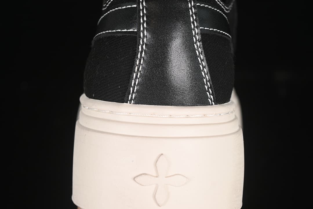 Rear view of the sneaker showing contrast stitching and a small emblem on the platform sole.