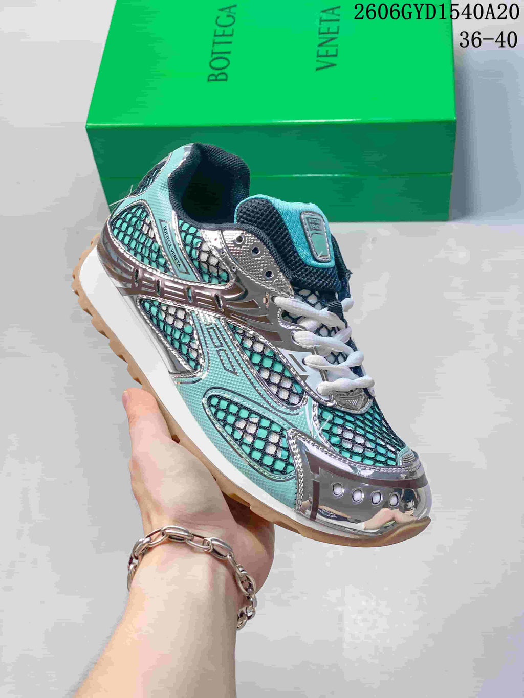 Angled view of the turquoise, black, and silver lace-up runner sneaker