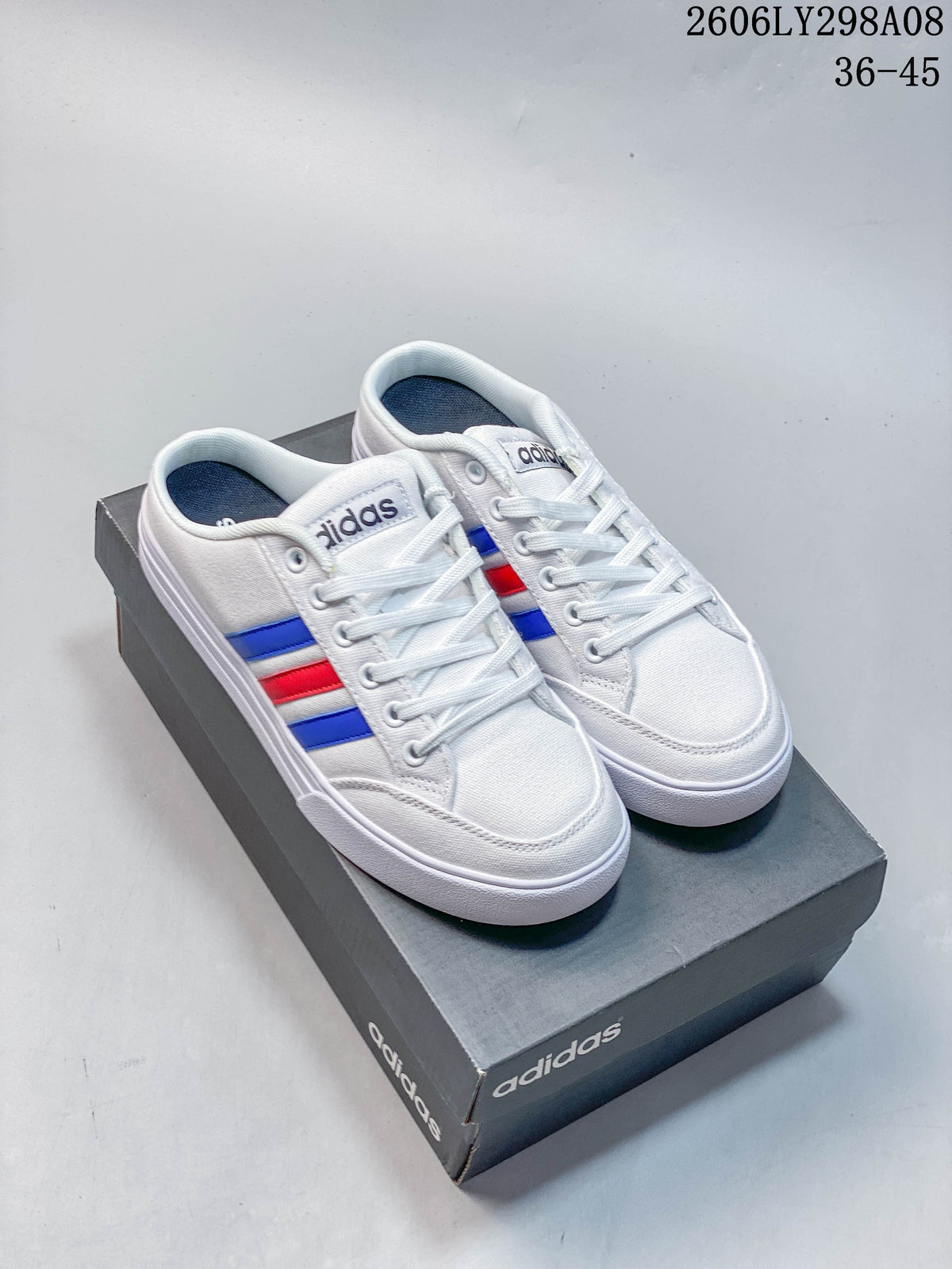 White adidas mule sneakers with blue and red side stripes, shown on a shoe box.
