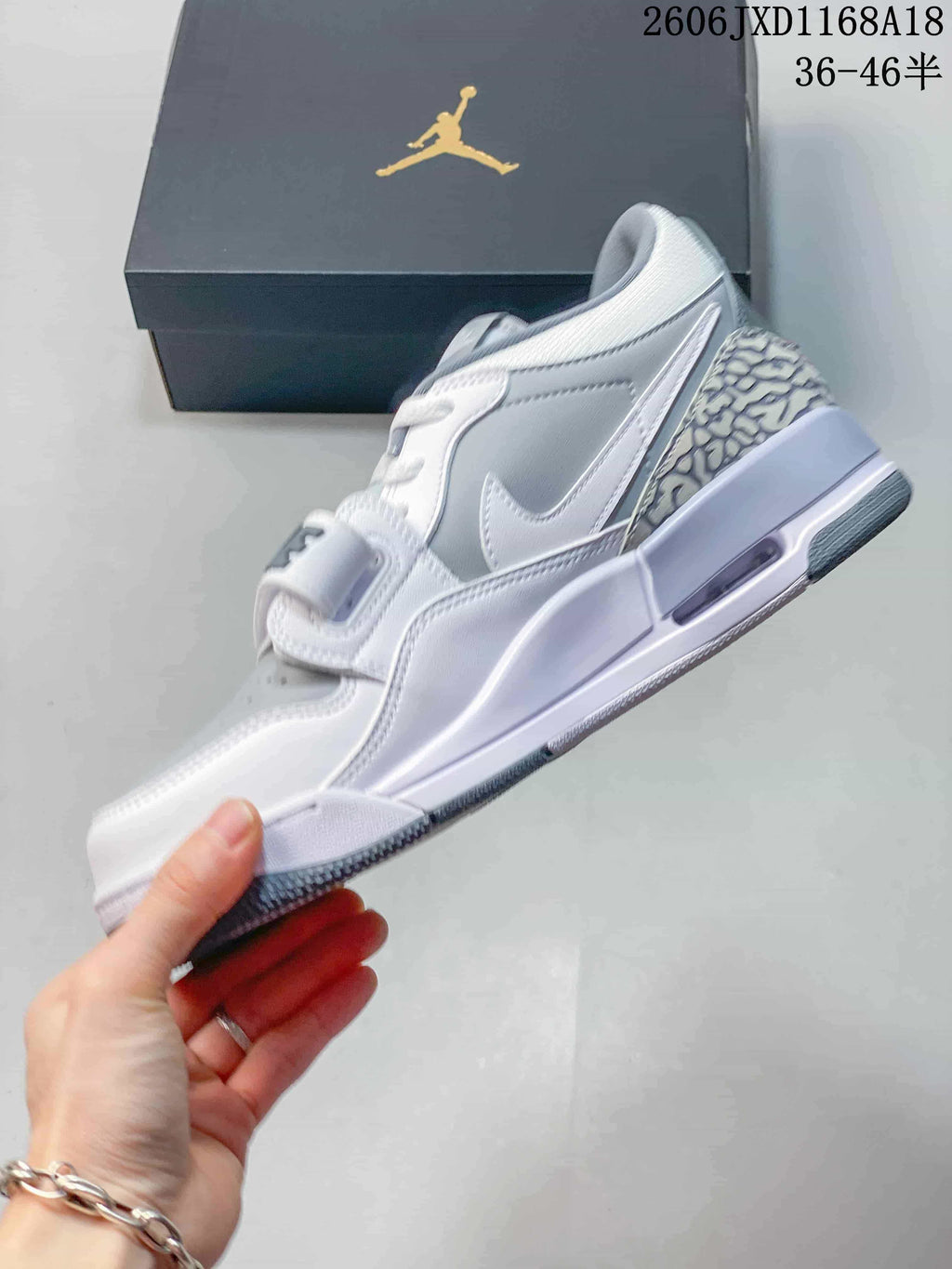 Side view of a white and grey Jordan Legacy 312 sneaker with a patterned heel panel