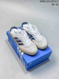 Pair of white Adidas Samba OG Mule sneakers with navy stripes and gum-colored soles