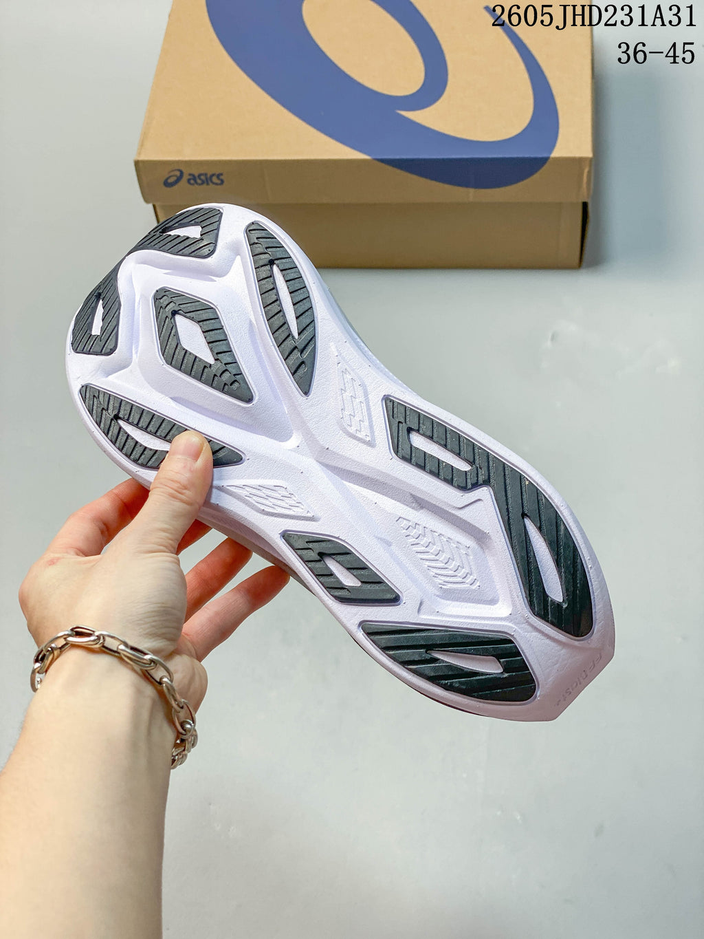 Underside of the shoe showing the white sole and dark outsole sections