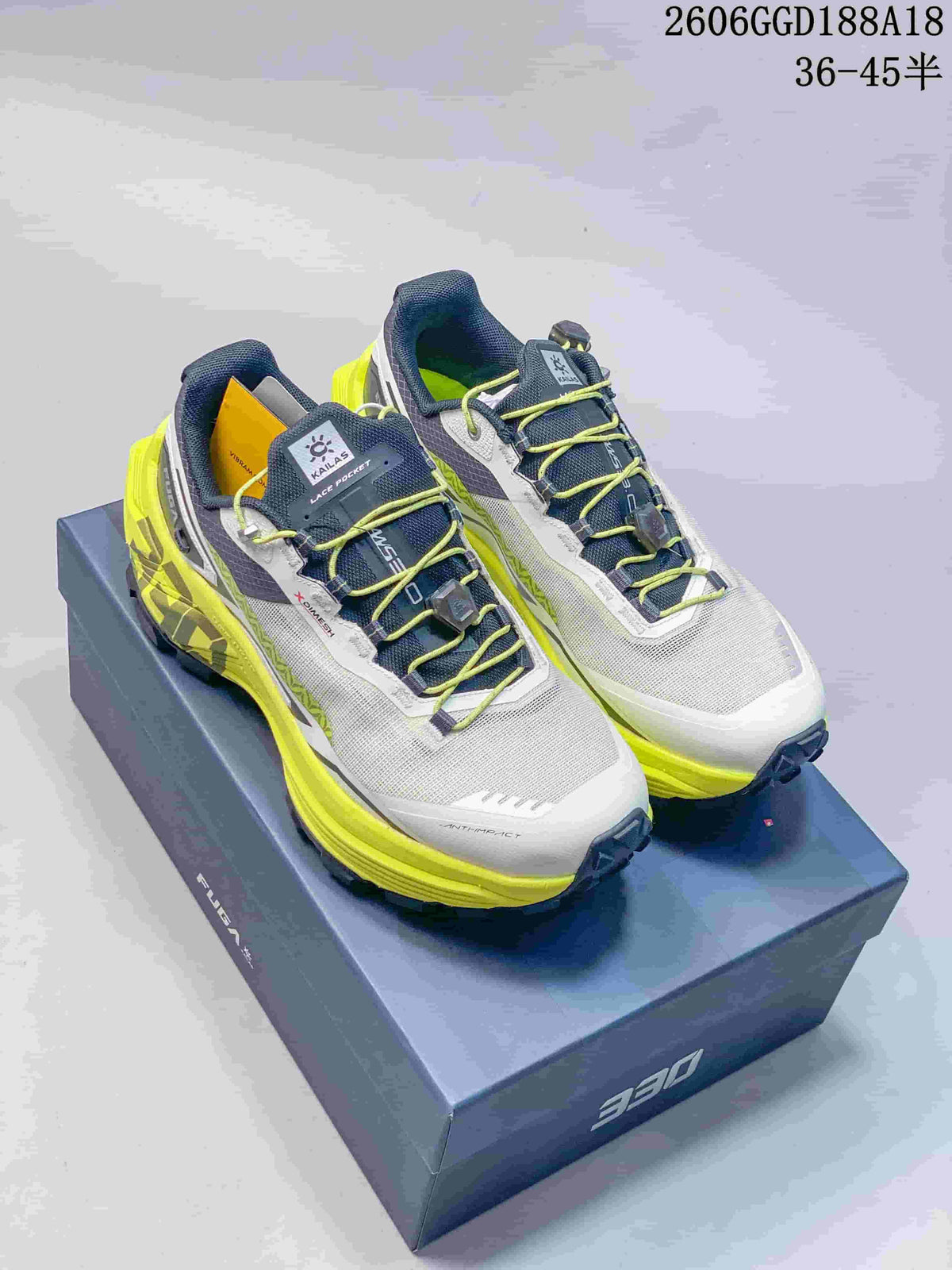 Pair of white, dark gray, and neon yellow Kailas FUGA EX330 trail running shoes on a box; image text shows style code 2606GGD188A18 and size range 36–45.5.