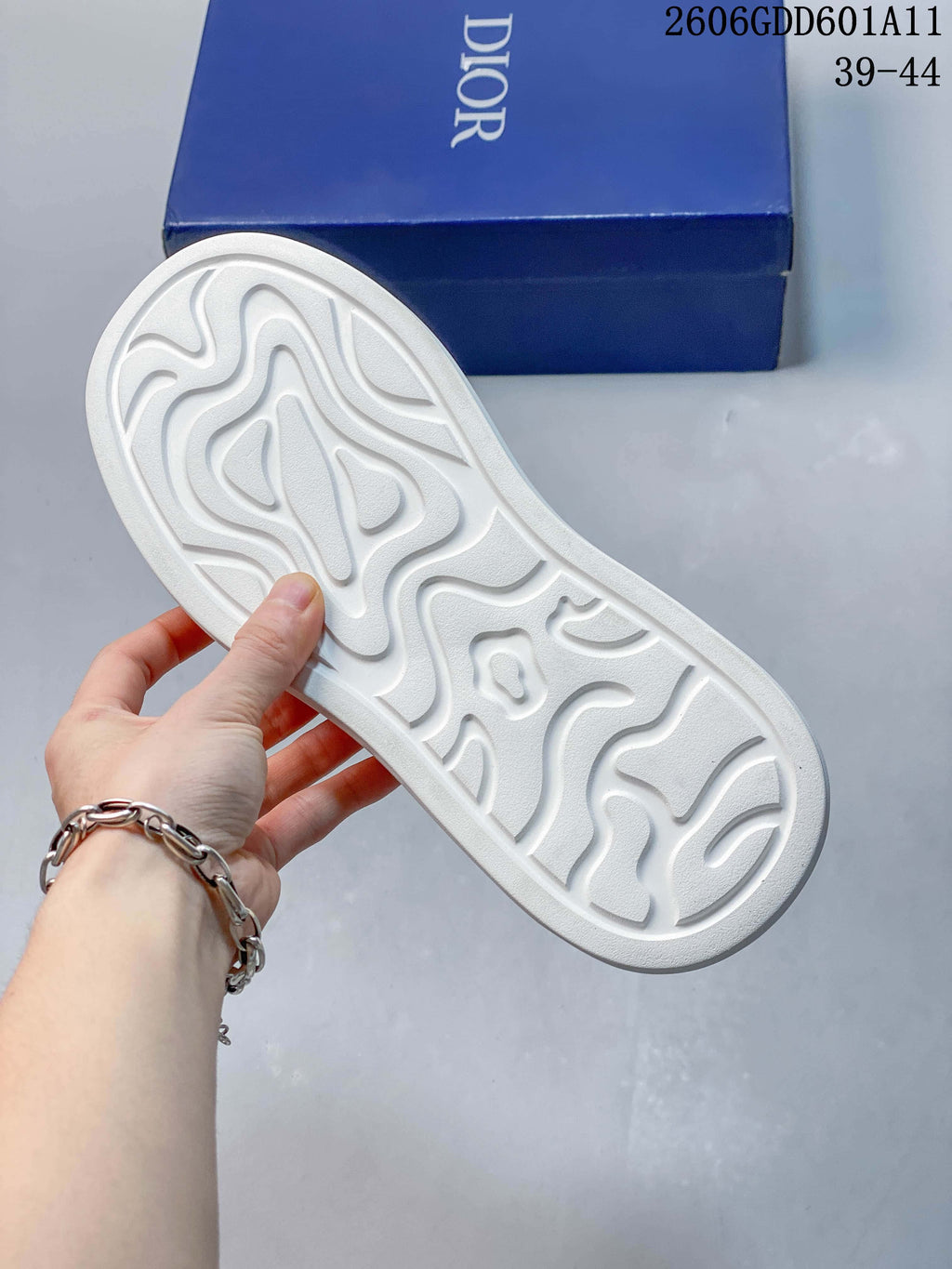 Underside of the sneaker showing its sculpted white outsole; a blue shoe box is in the background, and the image marking shows sizes 39–44.