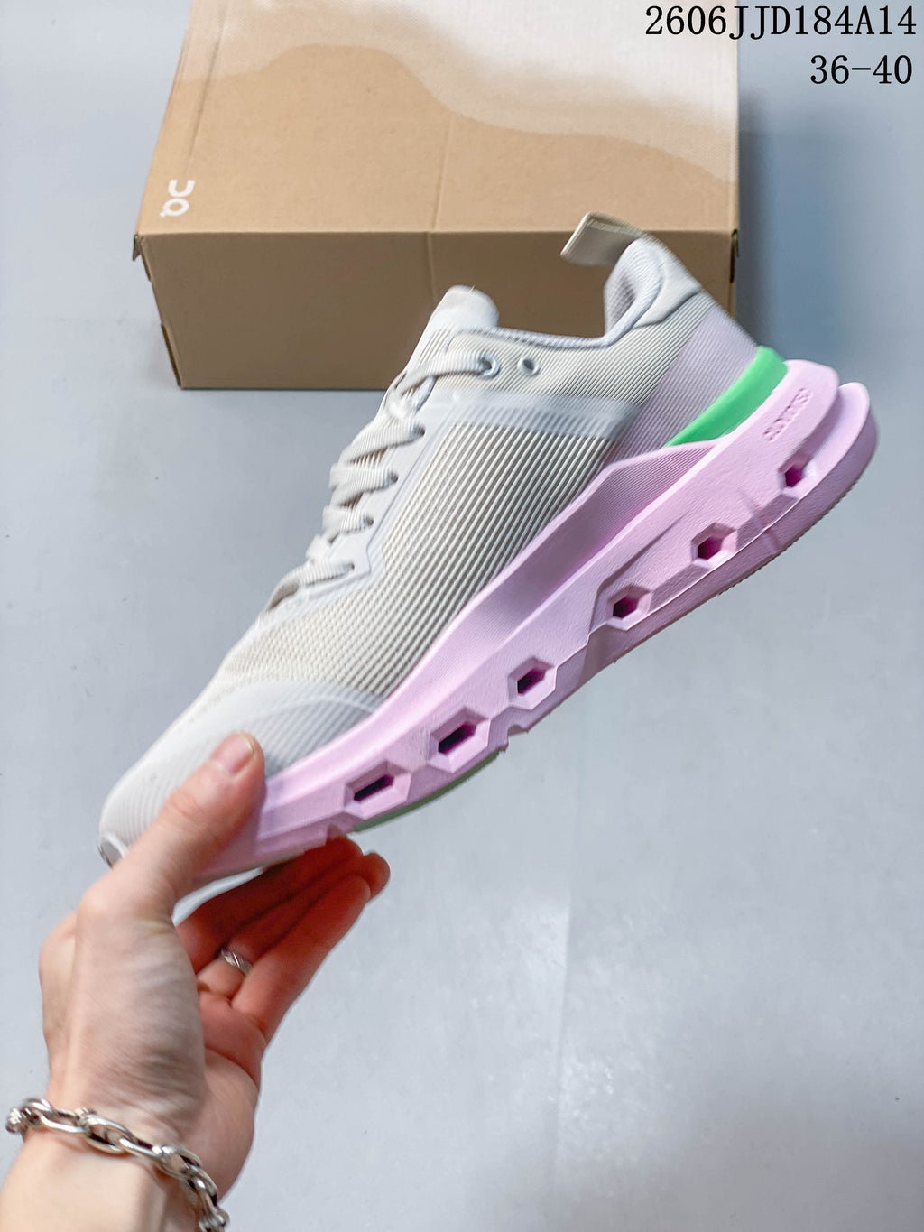 Side profile of the gray sneaker with a pink sculpted sole