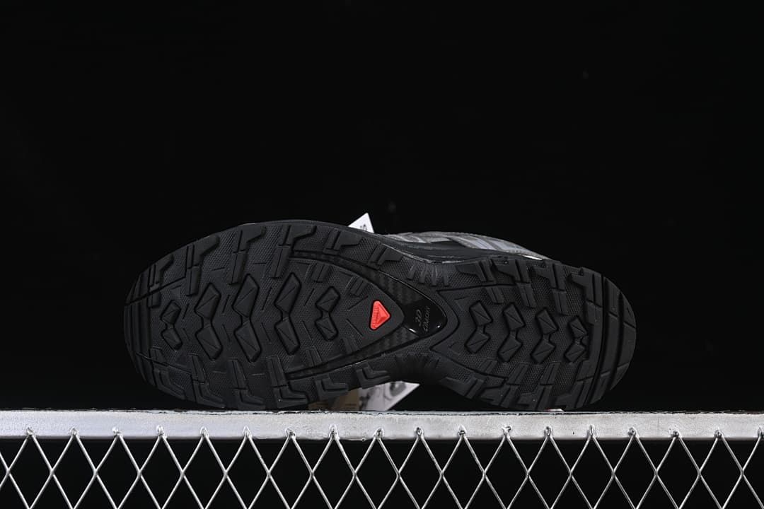 Underside view showing the black lugged outsole and a red accent.