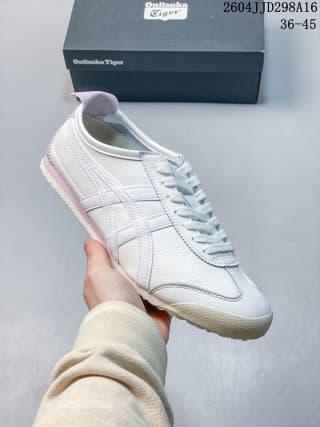 Angled side view of the white sneaker showing layered panels, side stripes, laces, and a light pink heel accent.