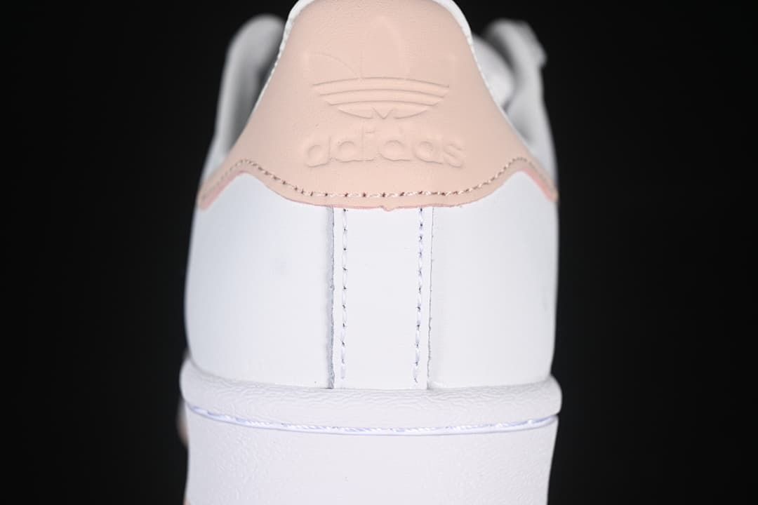 Rear view of the sneaker with blush-pink heel tab and embossed branding.