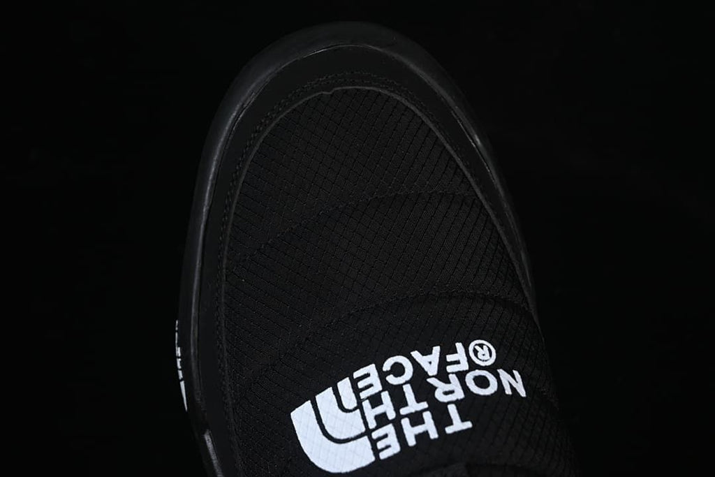 Top-down close-up of the shoe's black textile-look upper