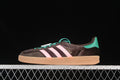 Side view of a dark brown adidas Gazelle Indoor sneaker with pink stripes, teal accents, and a gum-colored sole.