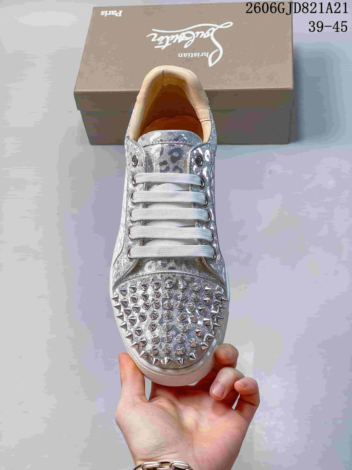 Top view of a silver sneaker with white laces and a studded toe