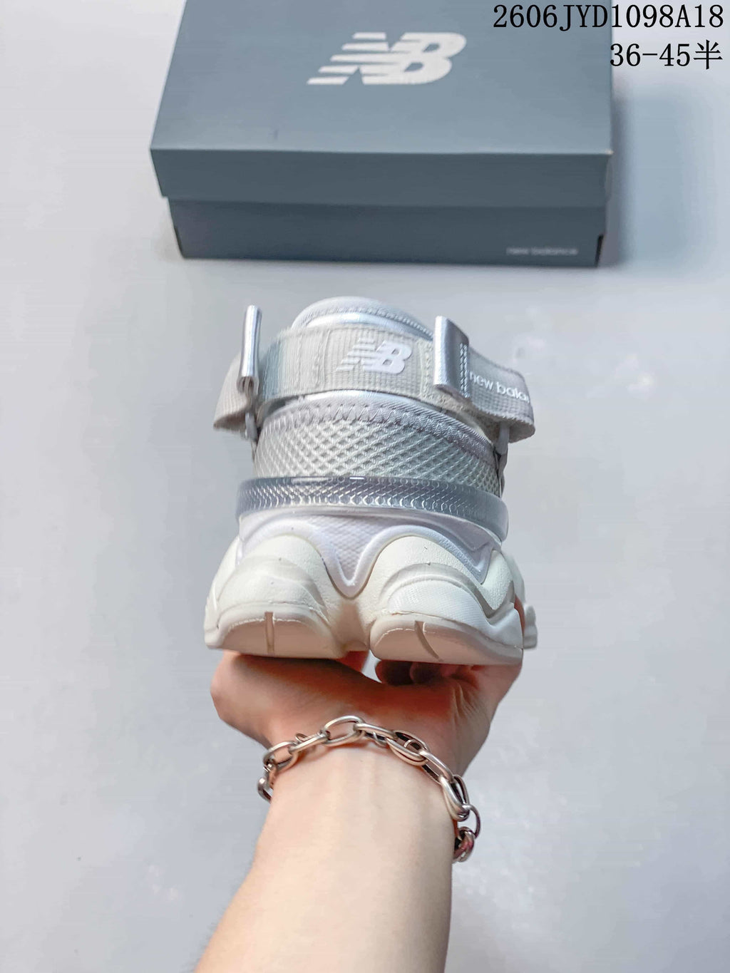 Rear view of the silver-toned sneaker with a heel pull tab.