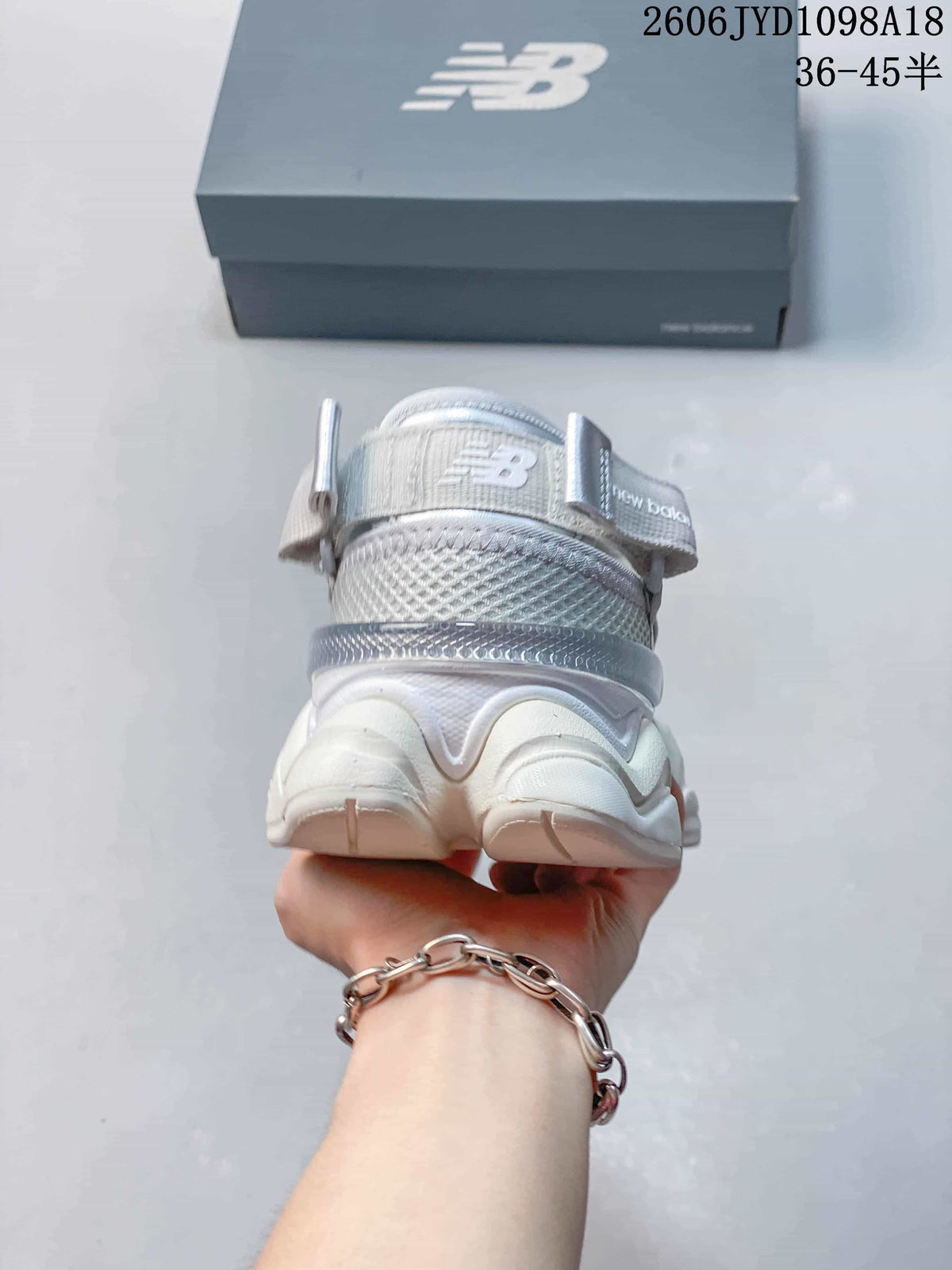 Rear view of the silver-toned sneaker with a heel pull tab.