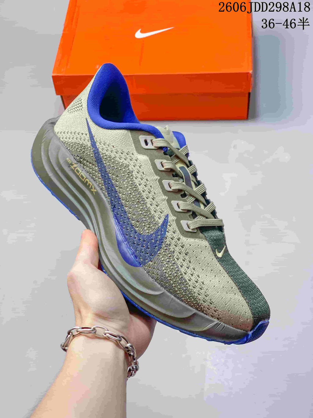 Side view of a gray-green running shoe with blue accents and a sculpted midsole