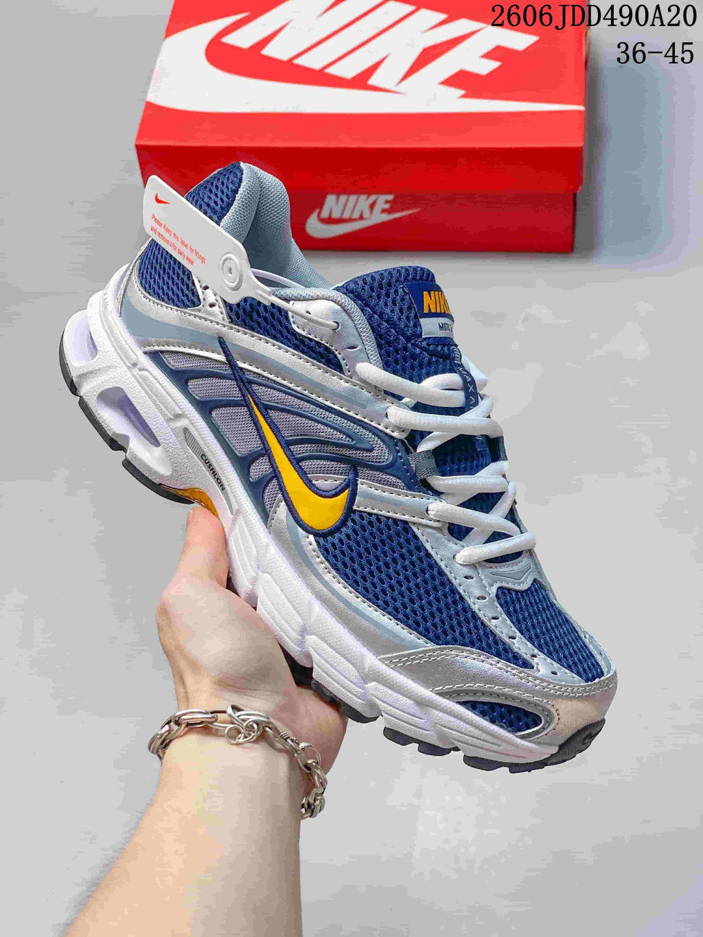 Blue and silver Nike Air Max Moto 2K sneaker with a yellow Swoosh accent