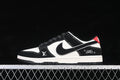 Side view of black and white Nike SB Dunk Low sneakers with red heel accents