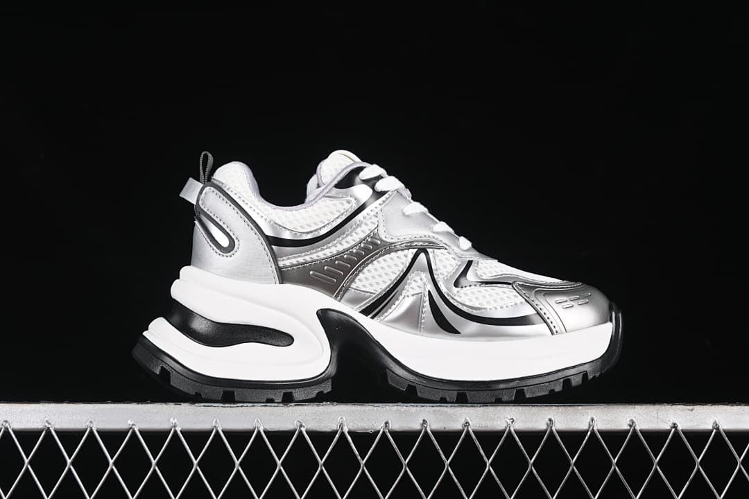 Side profile of one silver, white, and black sneaker