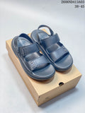 Pair of dark gray adjustable strap sandals shown on a box.