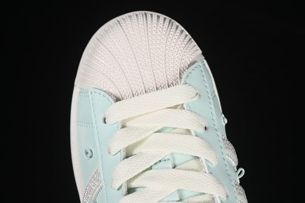 Top-down close-up of the shell toe and cream laces