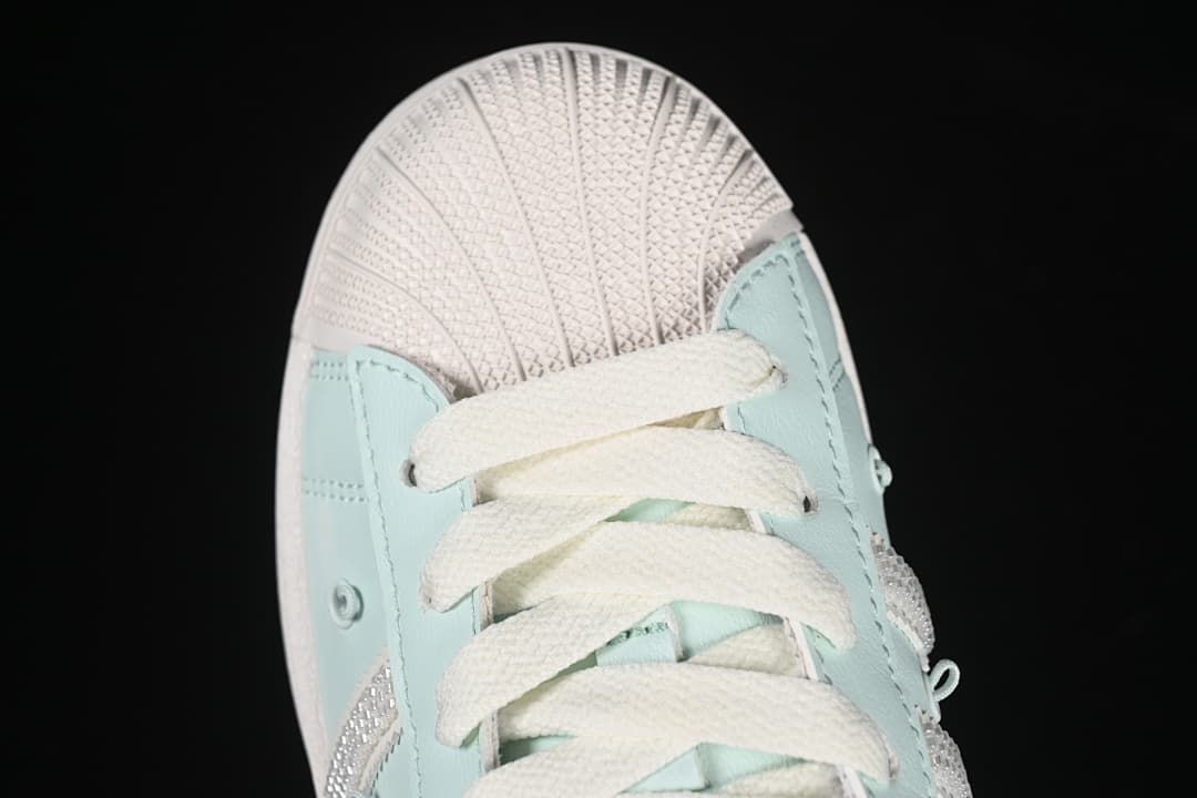 Top-down close-up of the shell toe and cream laces