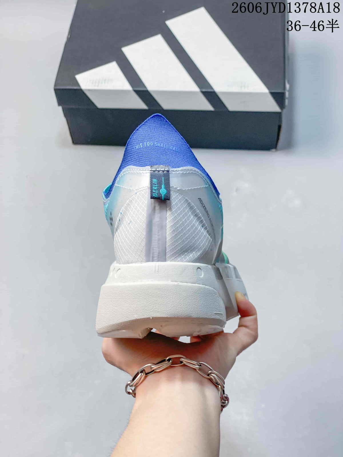 Rear view of a running shoe showing a white heel, mesh panels, and blue lining