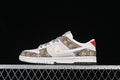 Side view of a low-top sneaker with a white swoosh, brown bee-patterned panels, patterned laces, and red heel accent.