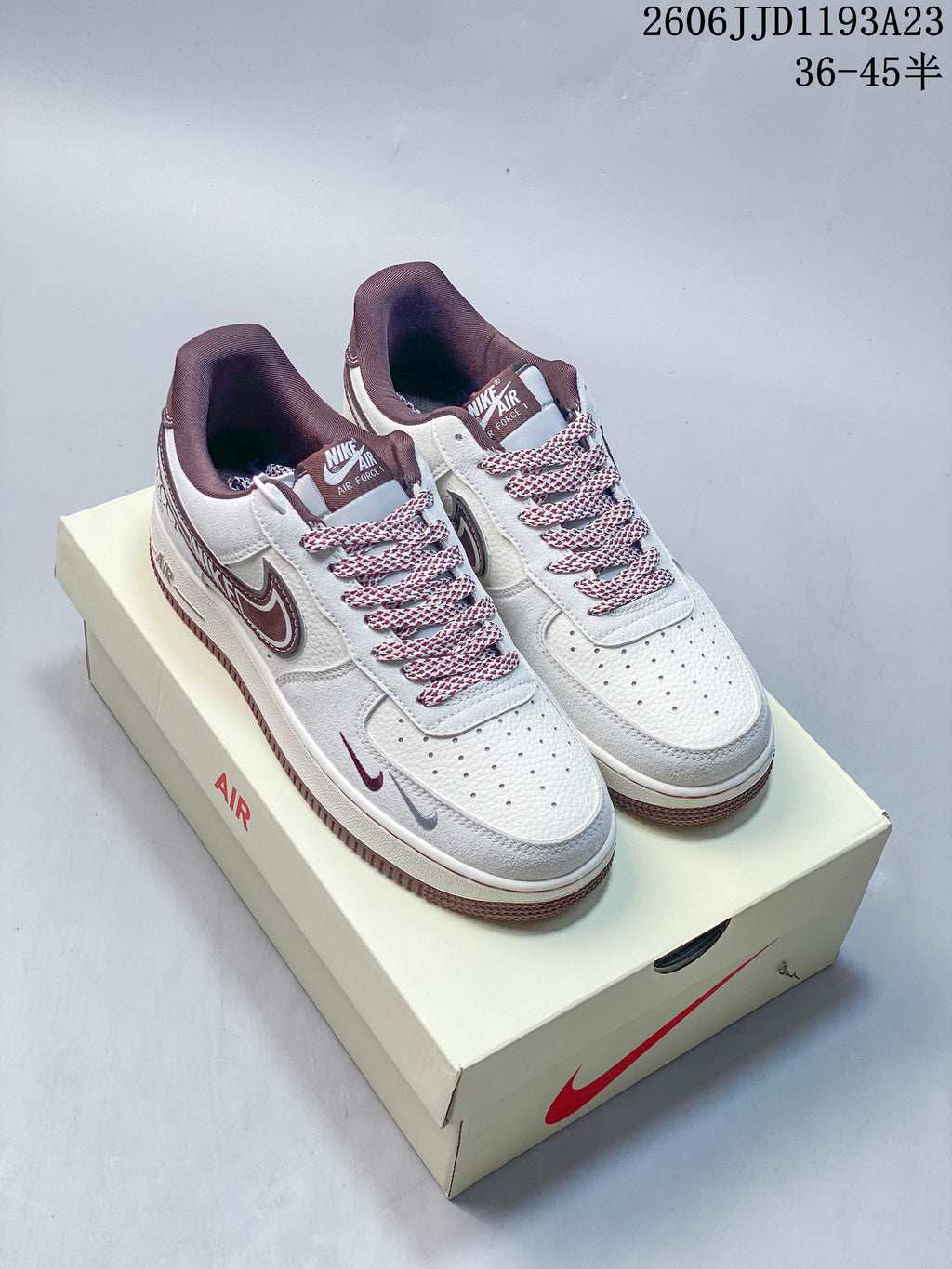 Pair of white and burgundy sneakers with patterned laces