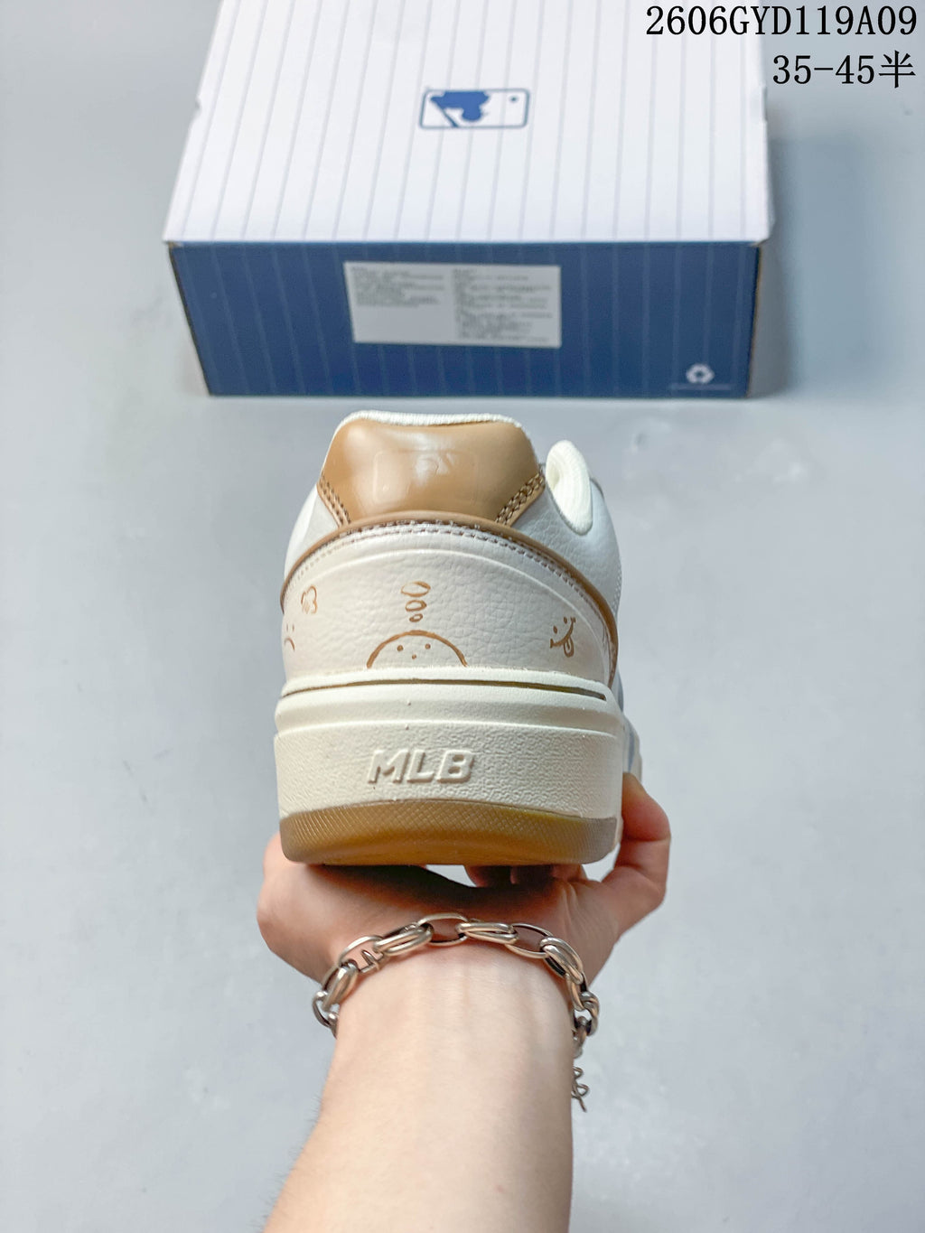 Rear view of a white sneaker with tan heel accents and a chunky sole