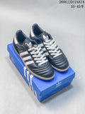 Pair of dark blue adidas Samba sneakers with white stripes and laces, shown on a blue shoebox