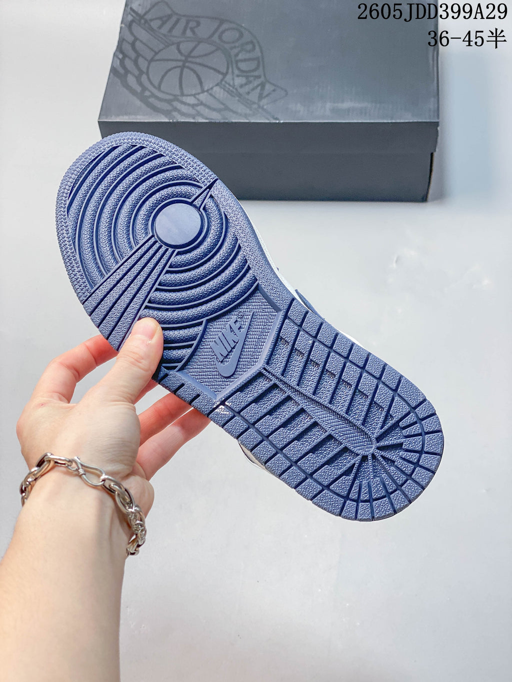 Blue outsole of the low-top sneakers shown beside a shoe box