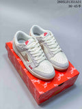 Pair of off-white Nike Dunk Low sneakers with taupe accents and embroidered details on a red patterned box