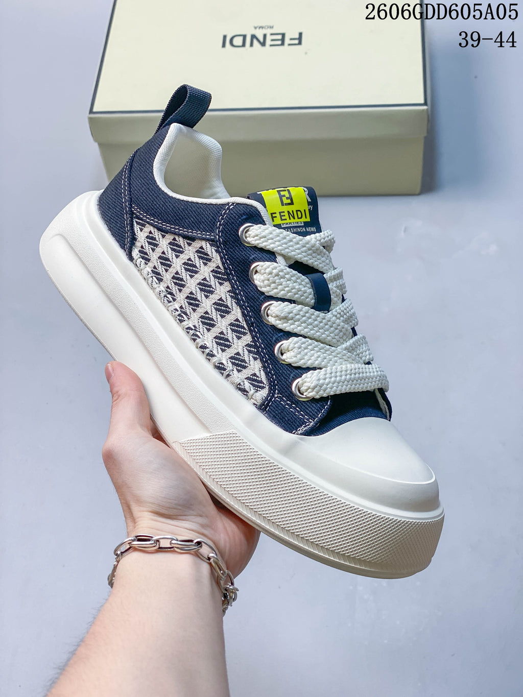 Angled view of a navy low-top sneaker with patterned side panels and cream laces.