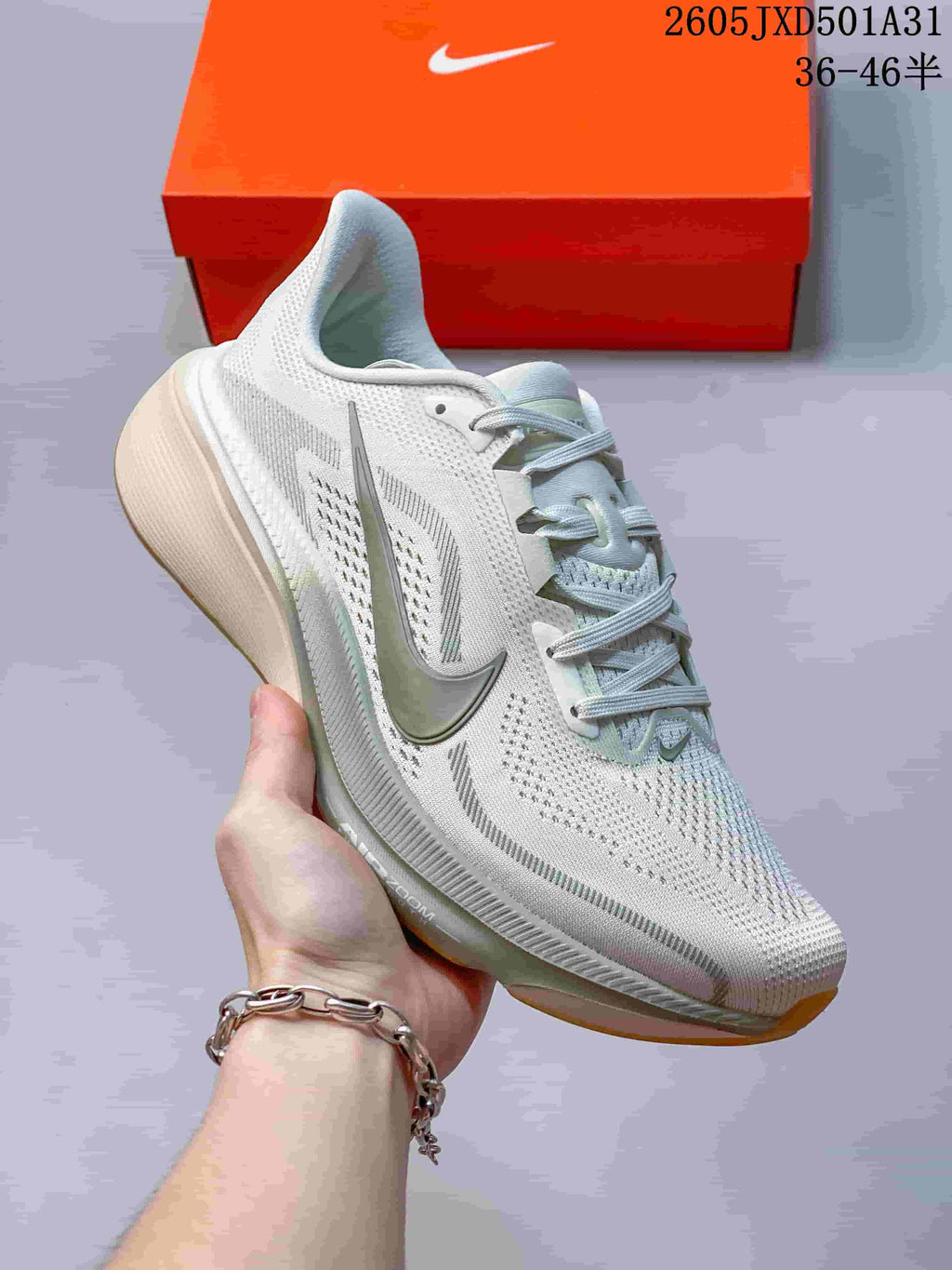 Angled side view of the light-colored running shoe showing its grey Swoosh and cushioned midsole