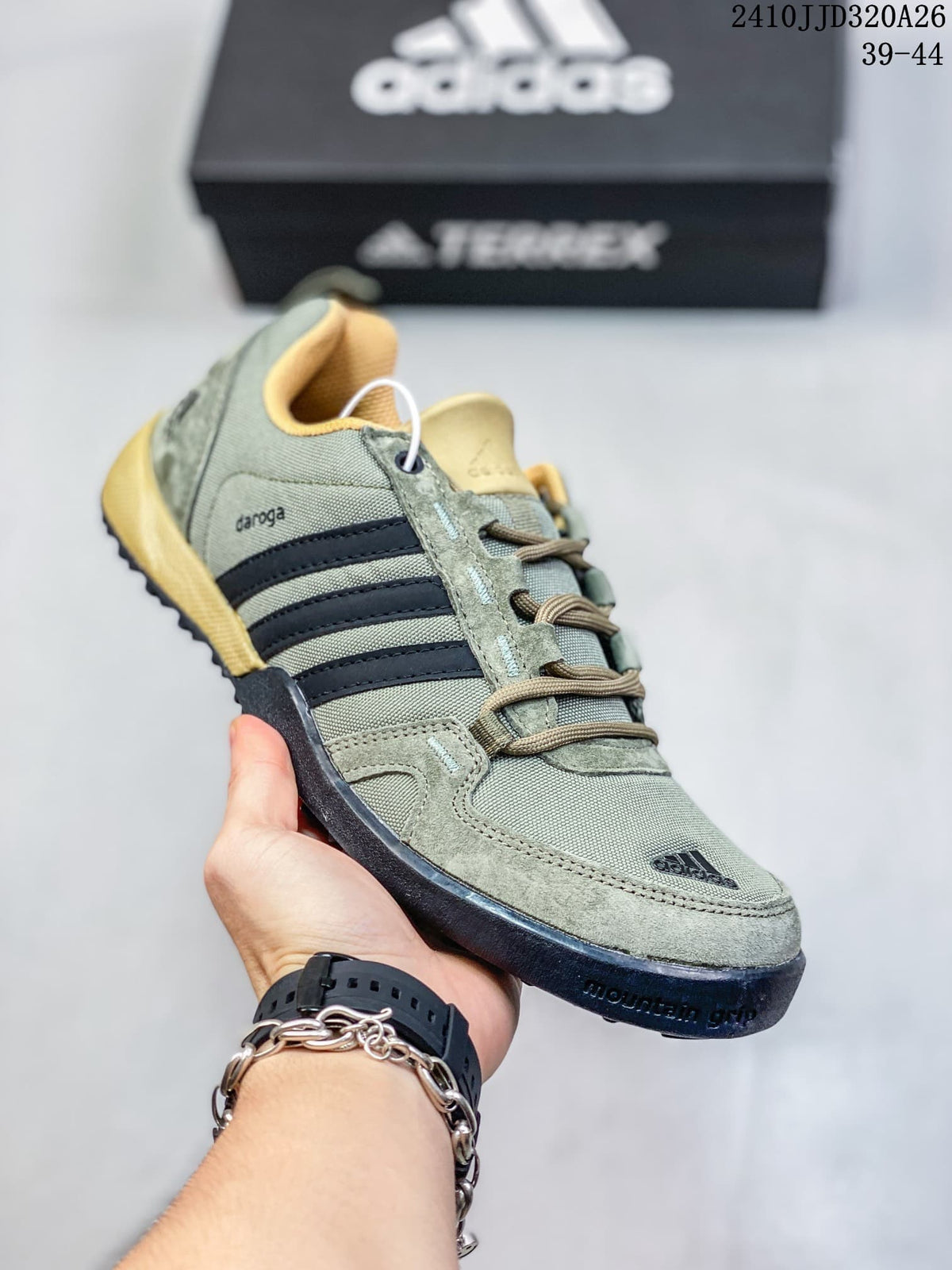 Angled side view of the green adidas Daroga shoe with dark stripes and tan accents.