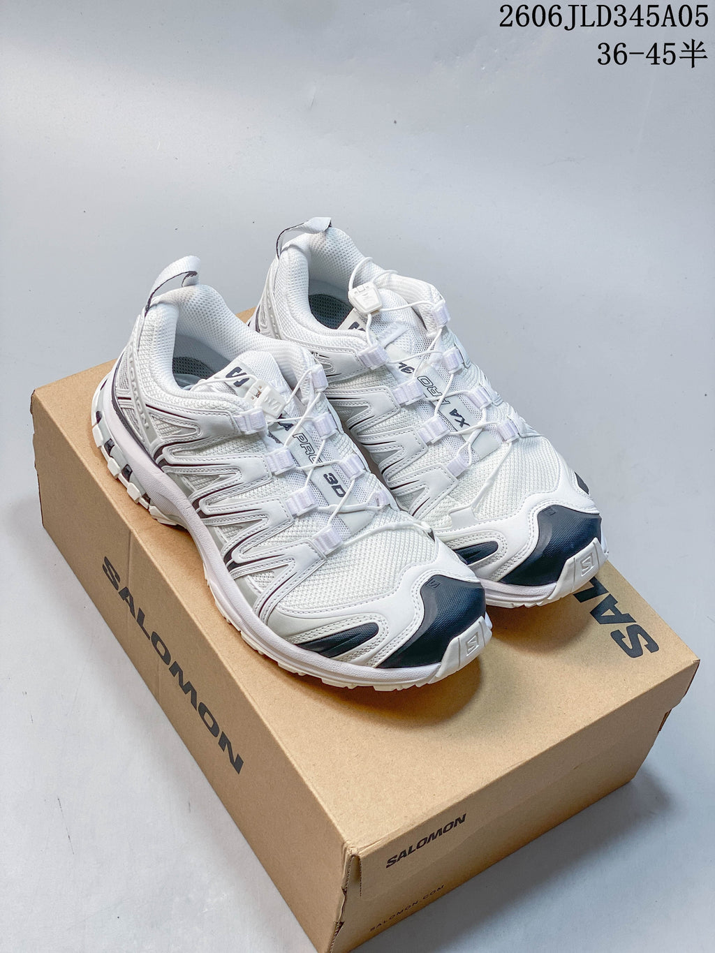 White and navy Salomon XT-3D trail running shoes displayed on a box