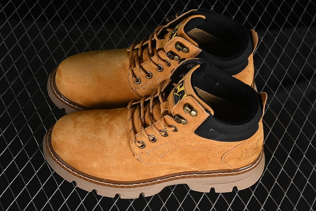 Pair of wheat-colored CAT mid-top boots shown from above