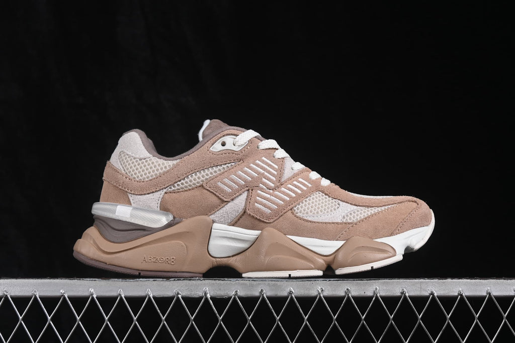 Side profile of beige and cream New Balance 9060 sneakers with mesh panels, layered overlays, and a sculpted sole.