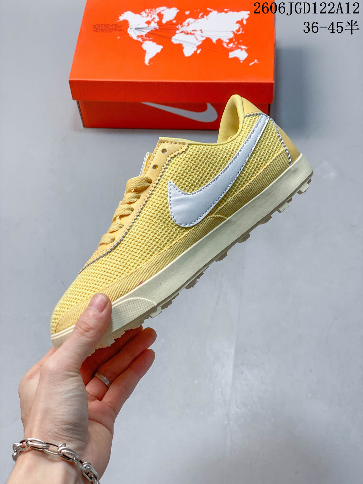 Side profile of a pale yellow Nike Astro Grabber sneaker with a white Swoosh and textured upper.