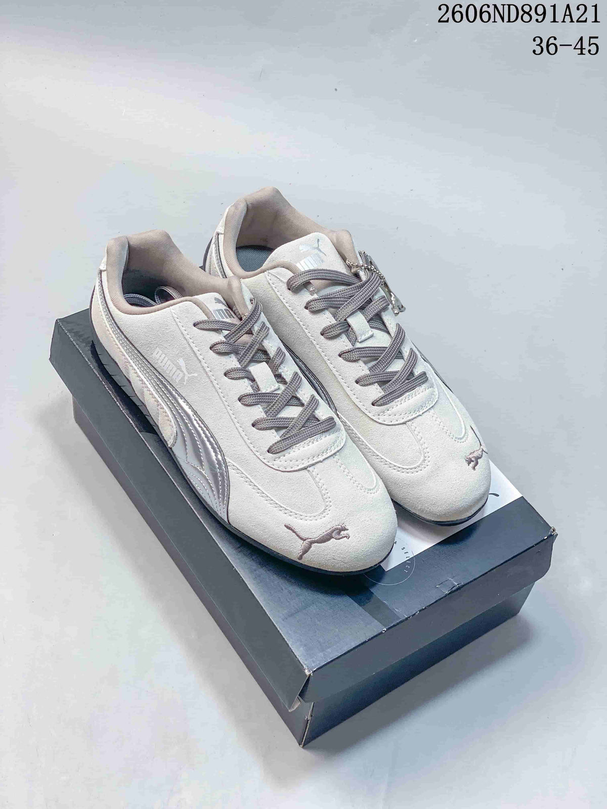 Pair of light gray Puma Speedcat OG sneakers with silver side stripes, gray laces, and dark outsoles