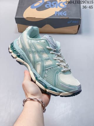 Three-quarter side view of a light sage and off-white ASICS sneaker with layered panels and white laces.
