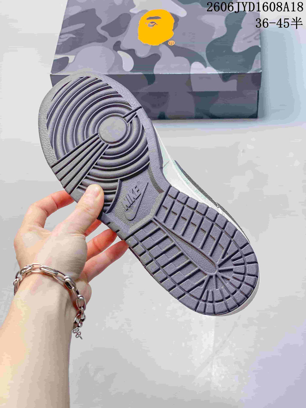 Outsole view of the sneaker showing circular tread and a camouflage-patterned box