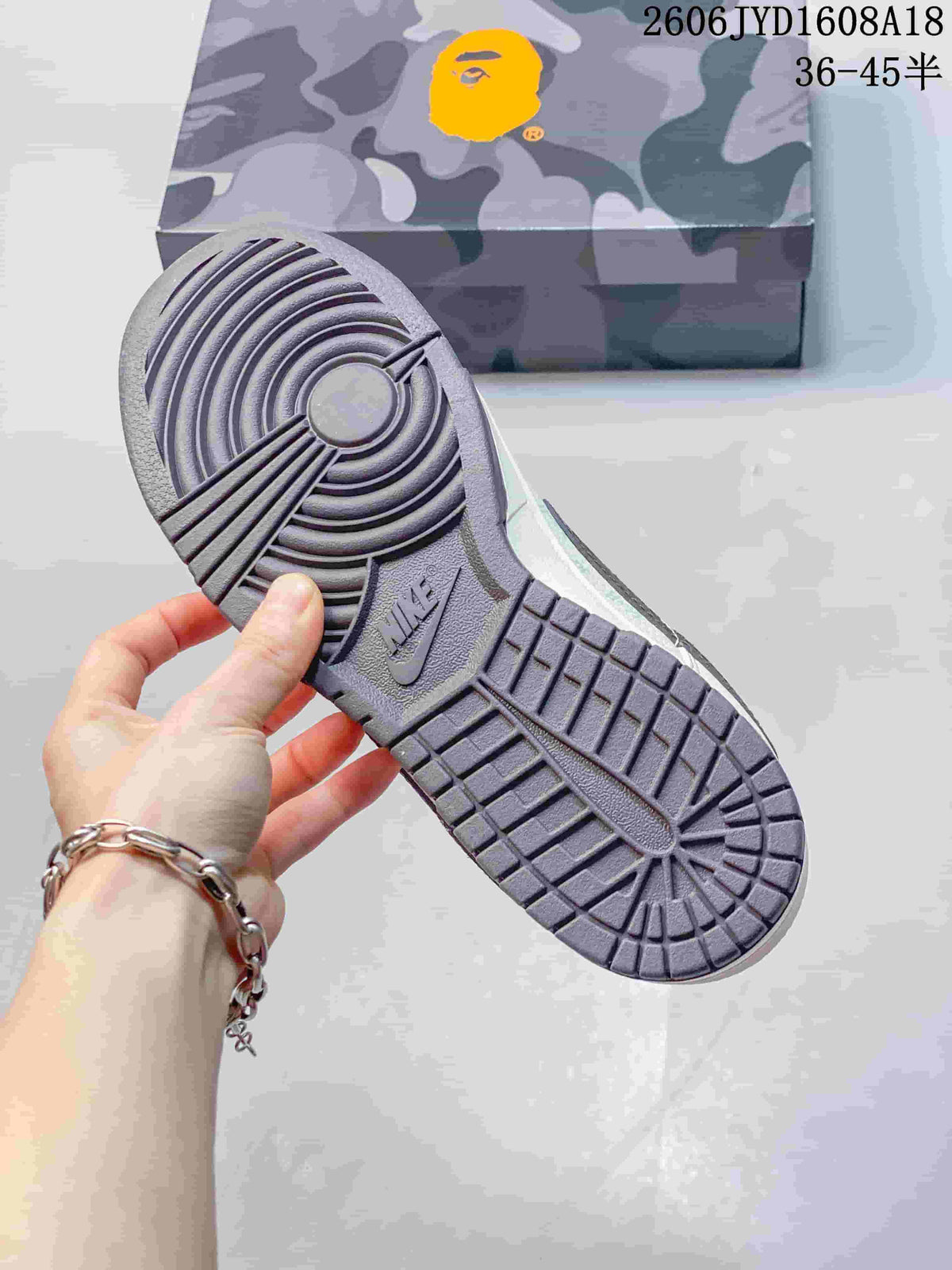 Outsole view of the sneaker showing circular tread and a camouflage-patterned box